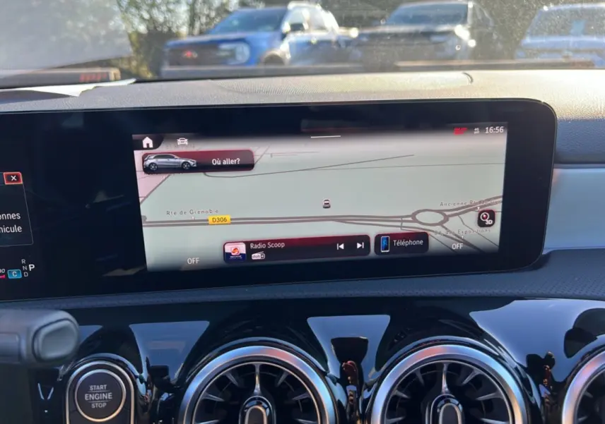 Vue intérieure du tableau de bord de la Mercedes Classe A 200D Exclusive Design avec écran tactile GPS et aérateurs ronds noirs.