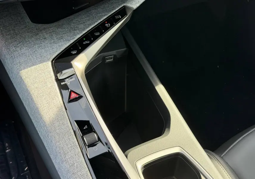 Gros plan sur la console centrale du Peugeot 3008 2026, avec tissu gris clair et commandes tactiles noires.