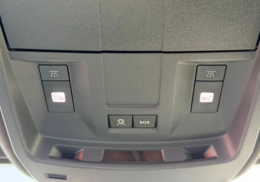Vue en gros plan du plafonnier noir avec boutons d'éclairage et commandes SOS du Peugeot 3008 Hybrid 2026.