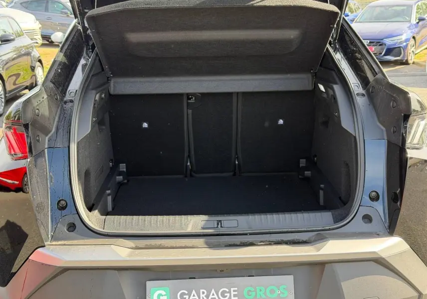 Coffre ouvert vu de l'arrière d'un Peugeot 3008 noir Perla Nera, montrant l'espace de chargement vide et la plage arrière relevée.