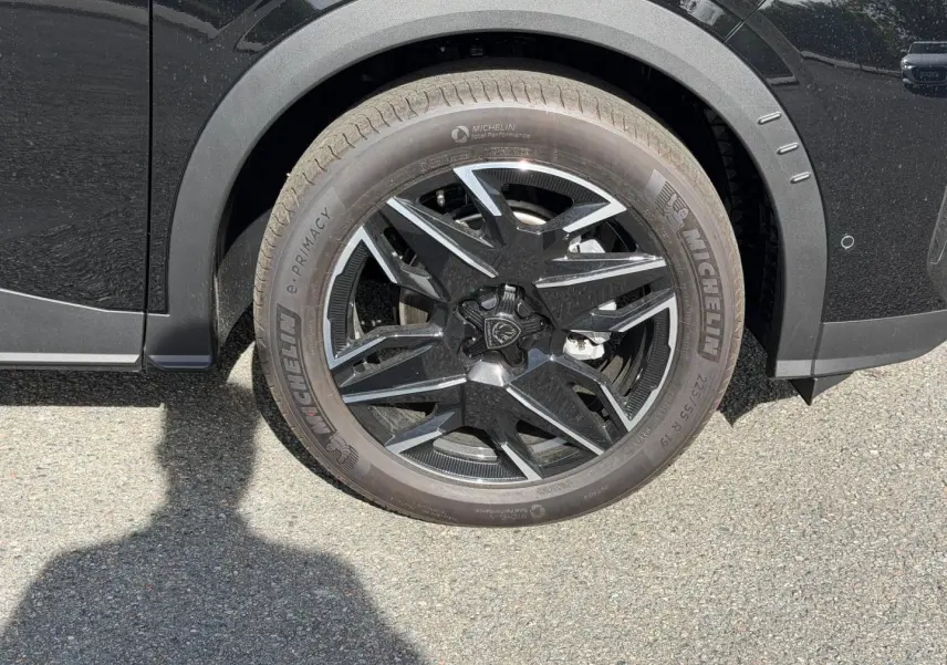 Gros plan sur la roue avant droite noire avec jante alu au design moderne du Peugeot 3008 noir Perla Nera.