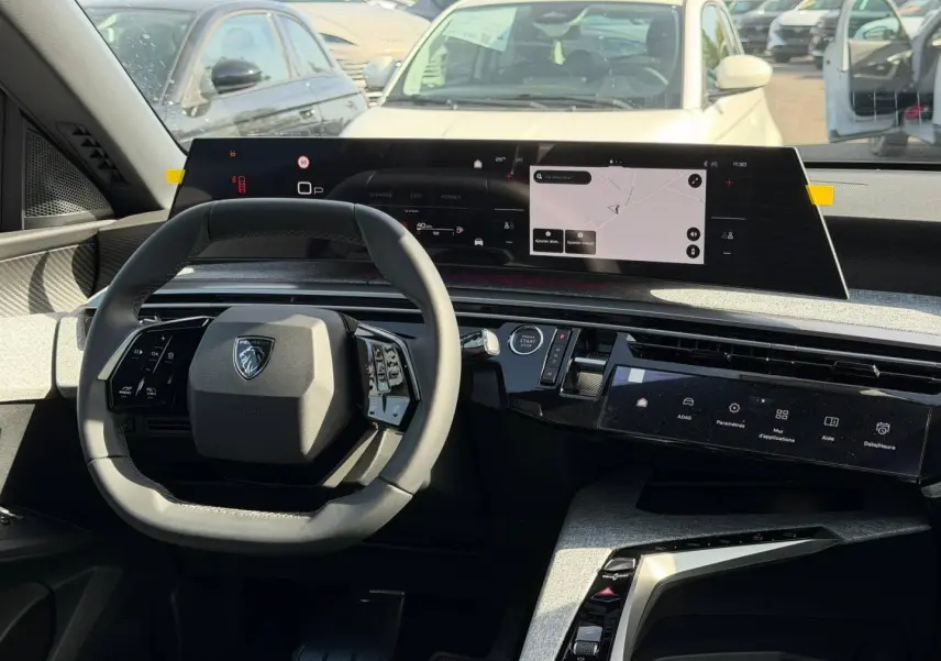 Intérieur du Peugeot 3008 hybride 2026 vu de face, volant cuir et double écran tactile moderne.