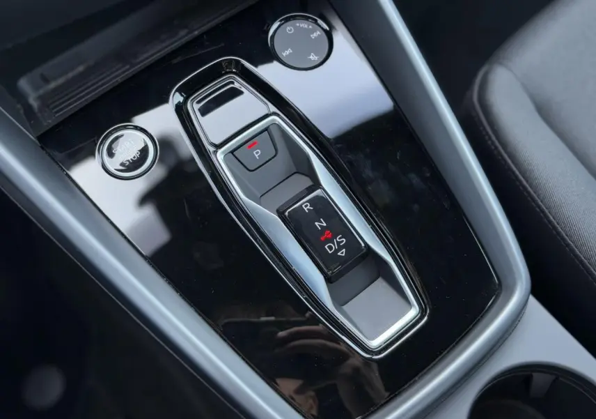 Le levier de vitesses automatique noir brillant de l'Audi A3 Sportback 2024 vu en gros plan intérieur.