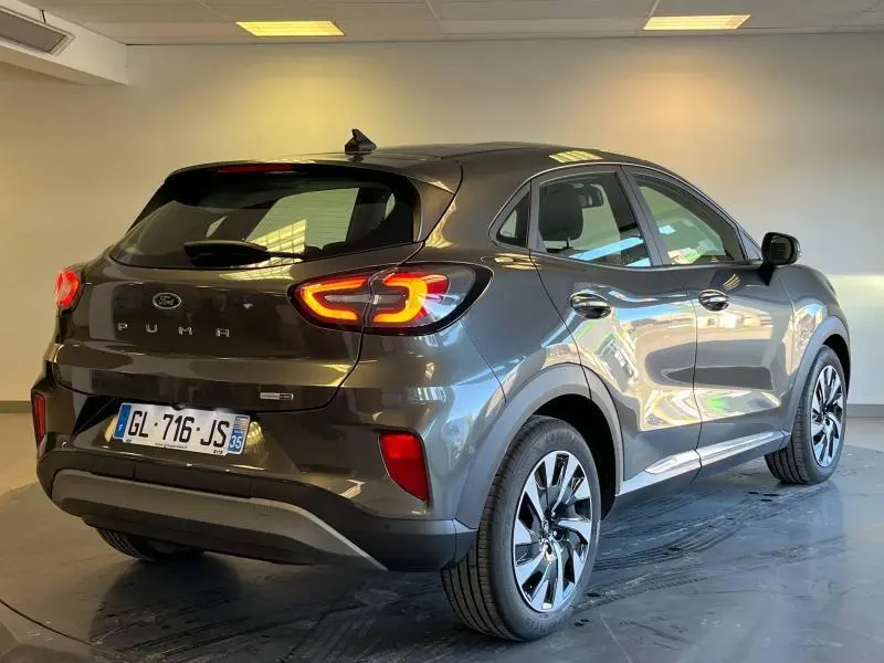 Vue 3/4 arrière droite d'un Ford Puma 2022 gris métallisé avec feux arrière LED et jantes alliage.