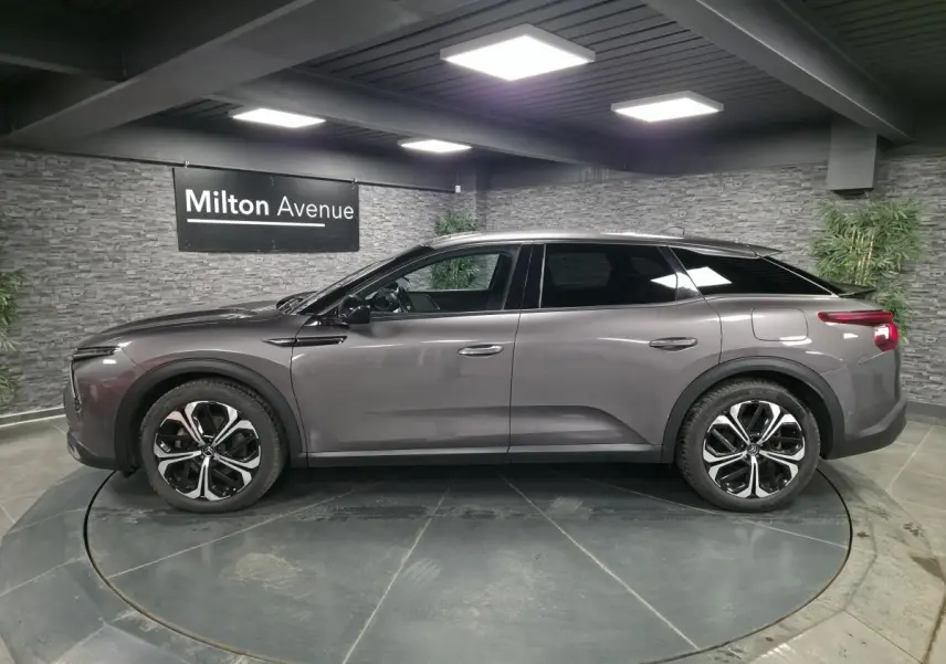 Profil côté gauche d'une Citroën C5 X hybride rechargeable gris métallisé avec jantes alliage 19 pouces AeroX.