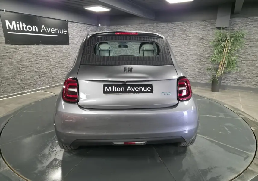 Vue arrière d'une FIAT 500 Cabriolet électrique gris foncé avec logo 500 bleu et plaque Milton Avenue.