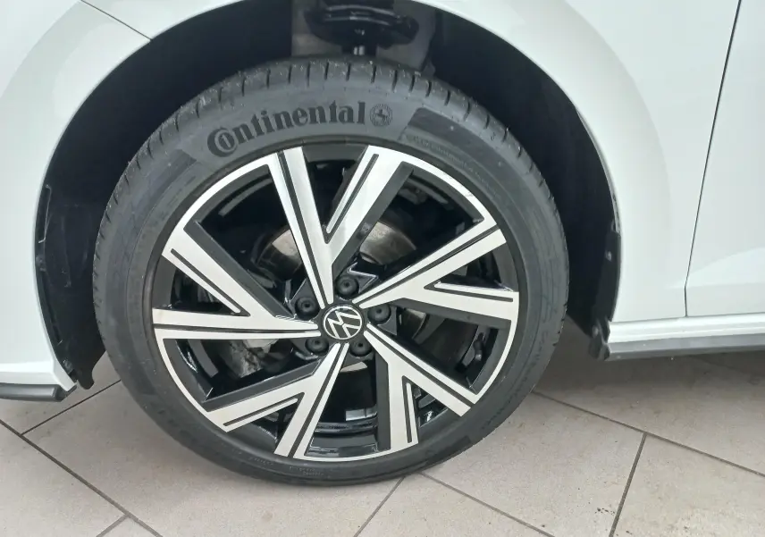 Gros plan sur la roue avant droite d'une Volkswagen Polo Blanc Pur avec jante alliage noire et argentée R-Line.