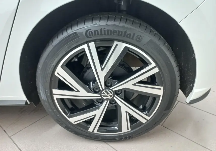 Gros plan sur la roue avant droite d'une Volkswagen Polo blanc pur avec jante alliage R-Line bicolore.