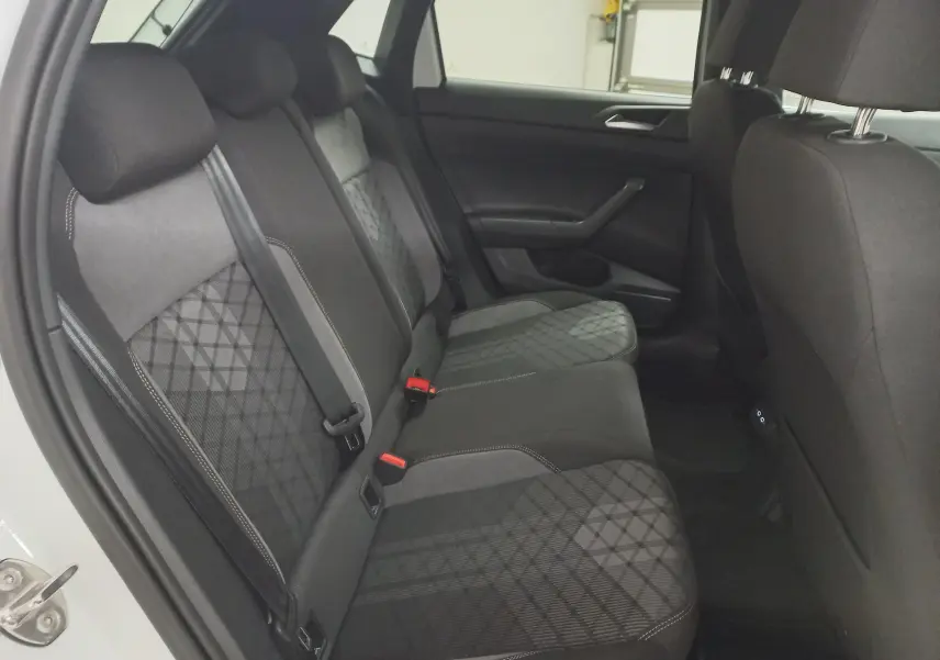 Vue intérieure côté gauche des sièges arrière en tissu noir et gris à motif géométrique d'une Volkswagen Polo 2025 Blanc Pur.