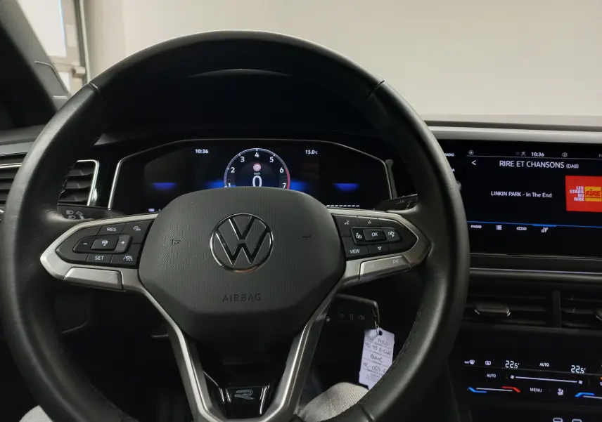 Vue rapprochée du volant noir de la Volkswagen Polo 2025 avec tableau de bord numérique et écran central allumé.