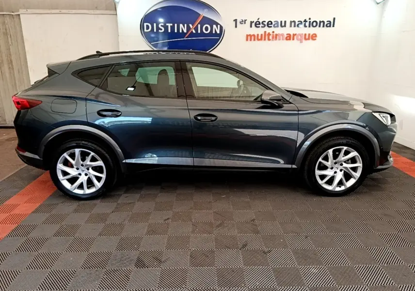 Vue de profil côté gauche d’un CUPRA Formentor gris foncé, SUV compact avec jantes alliage et lignes dynamiques.