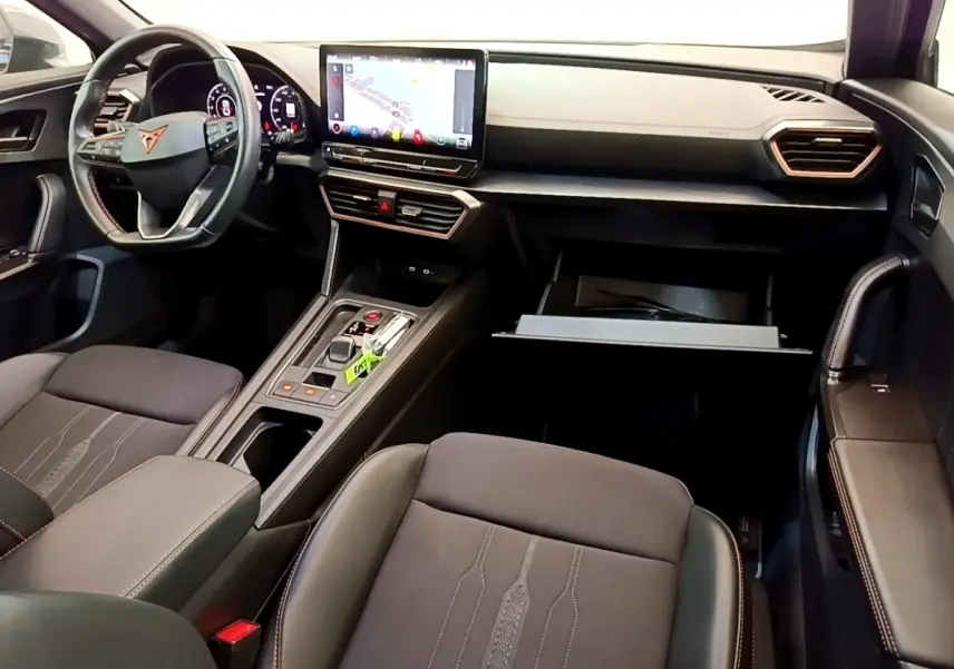 Intérieur avant de la CUPRA Formentor gris foncé, vue côté passager avec tableau de bord et écran tactile central visible.