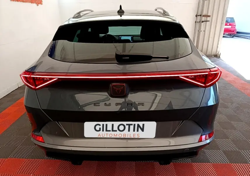 Vue arrière d'une CUPRA Formentor gris foncé avec feux LED reliés et logo central lumineux.