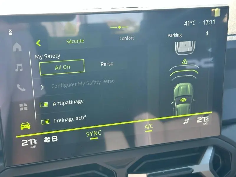 Écran tactile intérieur du Dacia Bigster blanc montrant les réglages de sécurité et assistance au stationnement.