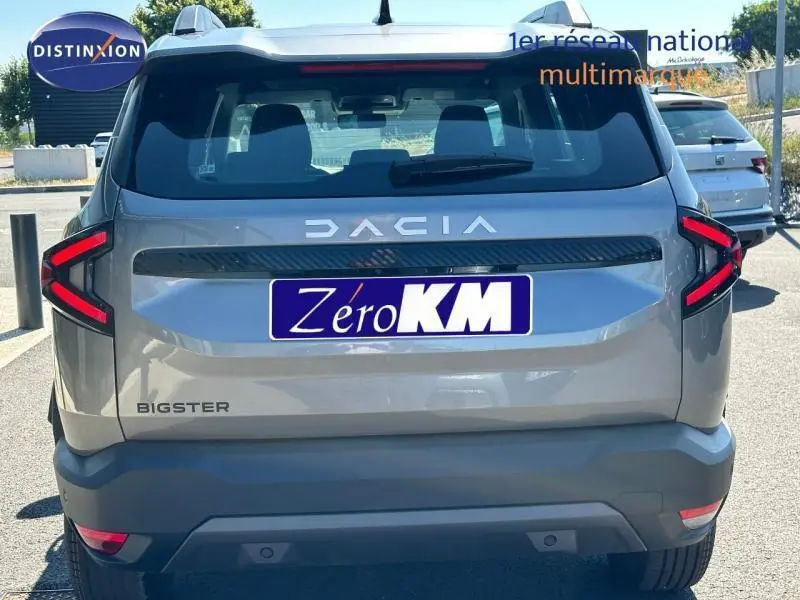 Vue arrière du SUV Dacia Bigster gris avec feux arrière LED en forme de flèche et logo DACIA bien visible.