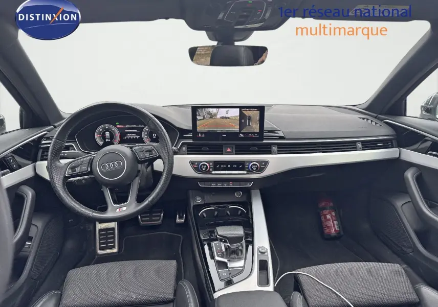 Intérieur Audi A4 Avant 35 TDI 2023, vue frontale du tableau de bord avec écran central et volant cuir noir.