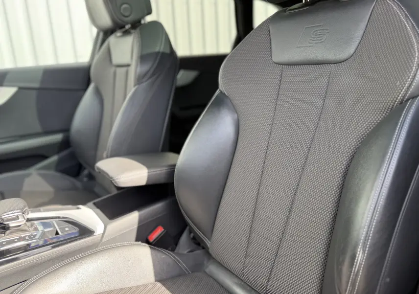 Gros plan sur les sièges avant noirs S-Line en cuir et tissu de l'Audi A4 Avant 35 TDI 2023, intérieur moderne.