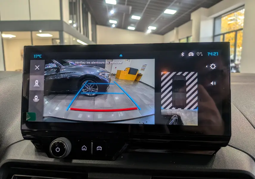 Écran de caméra de recul du Citroën Berlingo blanc glacier, montrant l'arrière et le côté droit en intérieur showroom.