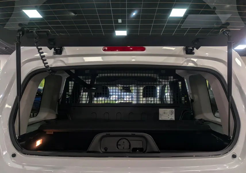 Vue arrière ouverte du Citroën Berlingo Blanc Glacier 2025, montrant l'espace de chargement et la grille de séparation intérieure.