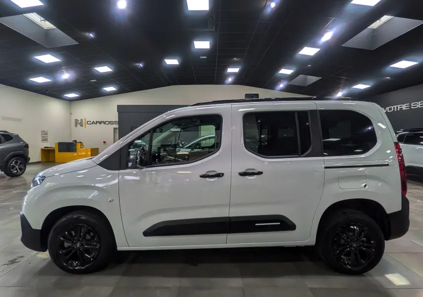 Profil latéral droit du Citroën Berlingo 2025 blanc Glacier avec jantes noires et protections latérales noires.