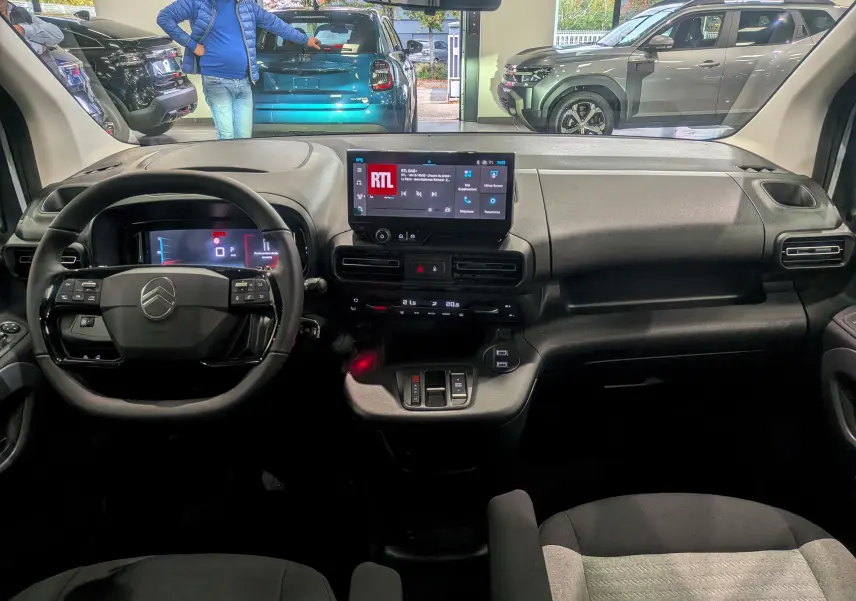 Vue intérieure du tableau de bord du Citroën Berlingo 2025, avec écran tactile central et volant multifonction noir.