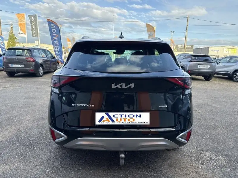 Vue arrière d'un Kia Sportage noir Basalte métallisé avec logo et feux arrière LED visibles sur parking.