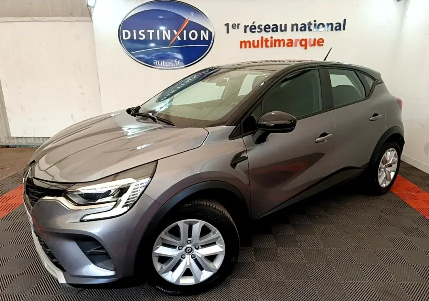 Renault Captur Zen E-Tech hybride gris foncé vu en 3/4 avant droit dans un showroom intérieur.