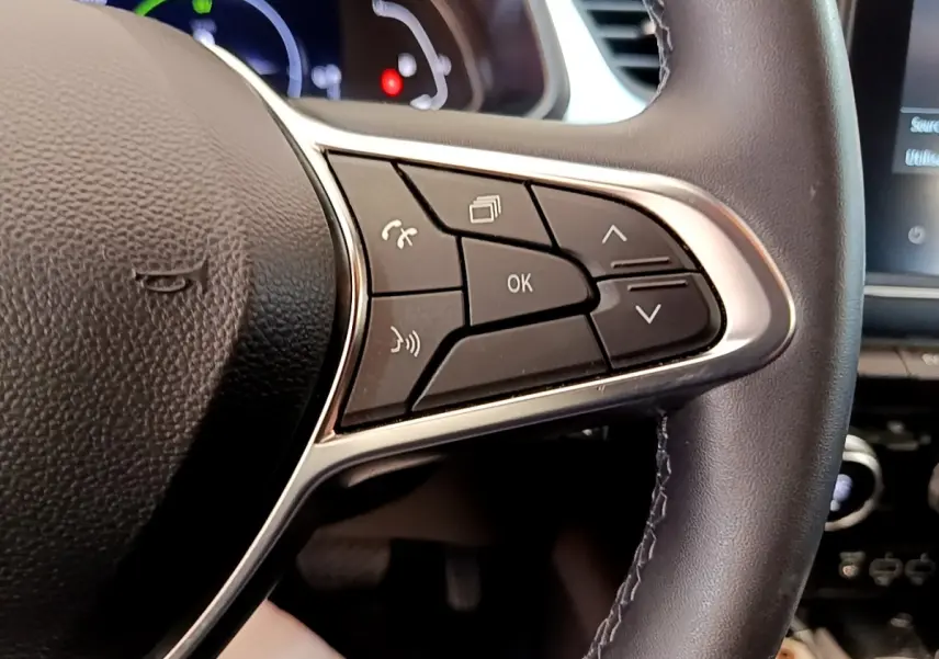 Gros plan sur les commandes multifonctions à droite du volant cuir noir du Renault Captur Zen E-Tech hybride 2022.