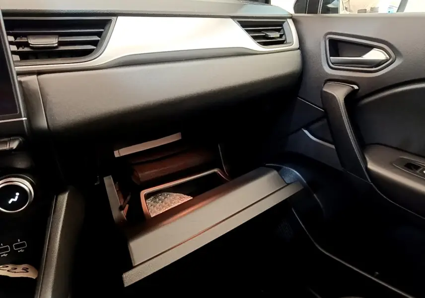 Intérieur du Renault Captur Zen E-Tech 2022, vue côté passager sur la boîte à gants ouverte et tableau de bord noir.