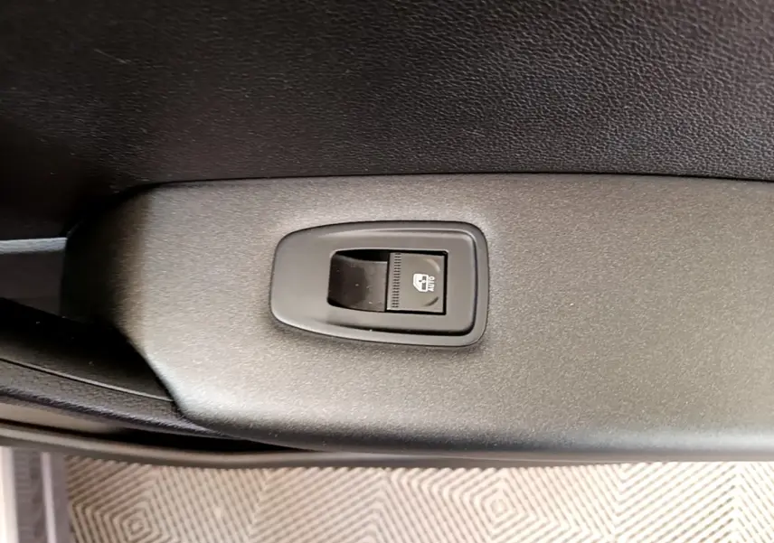 Gros plan sur le bouton de commande de la lunette arrière chauffante, intérieur noir du Renault Captur Zen E-Tech gris foncé.