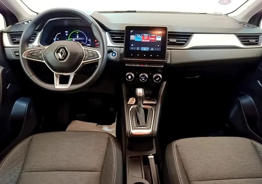 Vue intérieure avant du Renault Captur Zen E-Tech hybride 2022, tableau de bord noir avec écran tactile central et volant multifonctions.