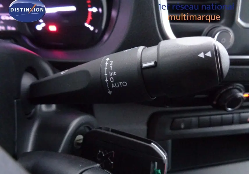 Gros plan sur la commande d'essuie-glace du Peugeot Expert gris, avec tableau de bord et console en arrière-plan.