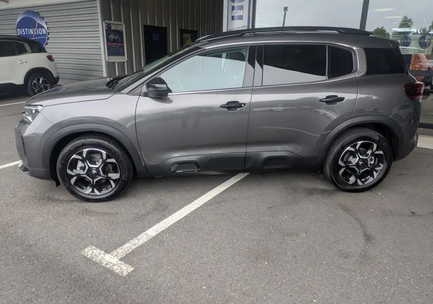Profil côté gauche du Citroën C5 Aircross hybride gris platinium avec jantes alliage biton 18 pouces, vitres arrière surteintées.