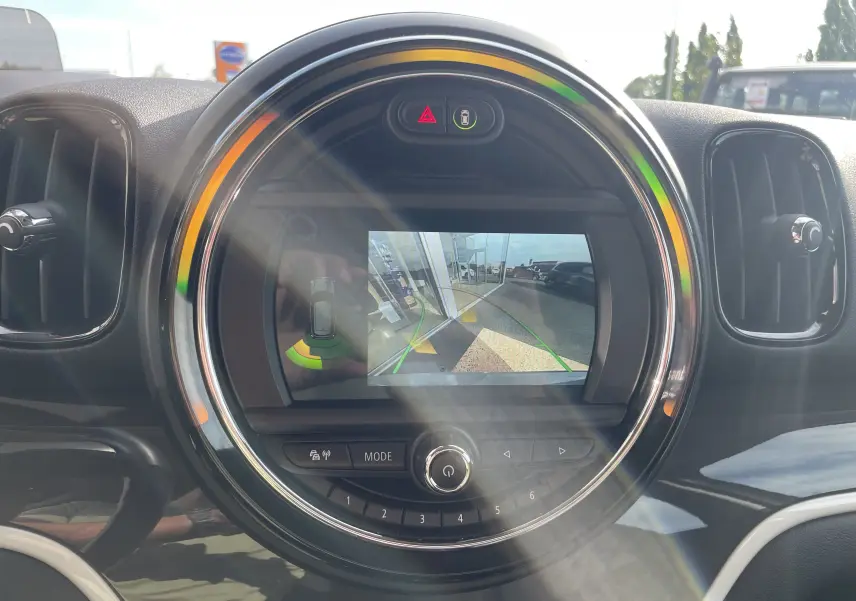 Écran central rond affichant la caméra de recul du MINI Countryman F60 hybride en intérieur noir et gris.