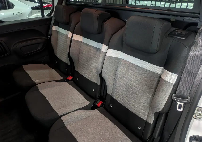 Vue intérieure des sièges arrière en tissu gris et noir du Citroën Berlingo Blanc Glacier 2025, version BlueHDi 130 CH EAT8 PLUS N1.