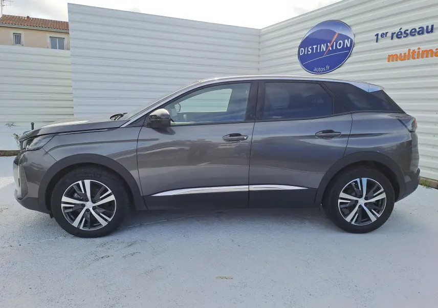 Profil côté gauche d'un Peugeot 3008 Hybrid gris platinium 2024 avec jantes alliage bicolores et vitres teintées.