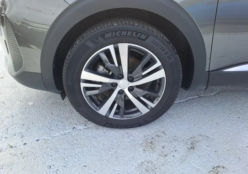 Gros plan sur la roue avant gauche du Peugeot 3008 gris platinium avec jante alliage et pneu Michelin.