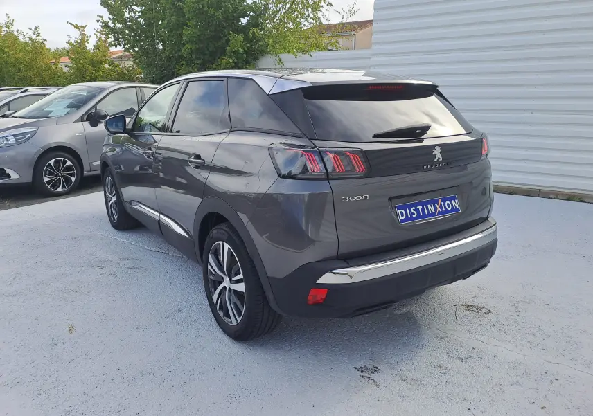 Peugeot 3008 gris platinium en vue 3/4 arrière droit, avec feux arrière à griffes et jantes alliage bicolores.