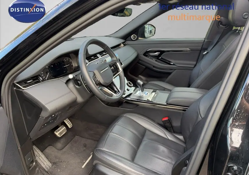 Intérieur du Range Rover Evoque 2023 en Santorini Black, vue côté conducteur montrant sièges cuir et tableau de bord moderne.