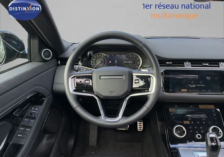 Intérieur du Range Rover Evoque 2023 en Santorini Black, vue centrée sur le volant et la console tactile moderne.