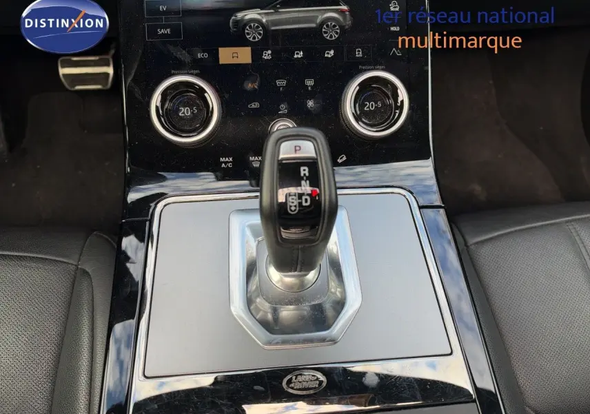 Gros plan sur la console centrale du Range Rover Evoque 2023 Santorini Black, avec levier de vitesse automatique et commandes tactiles.