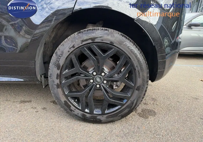 Gros plan sur la roue arrière gauche noire brillante d’un Range Rover Evoque Santorini Black avec jante alliage noire.