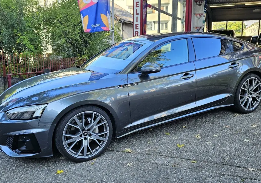 Audi A5 Sportback gris Daytona vue de côté droit en extérieur, avec jantes alliage et calandre s line.