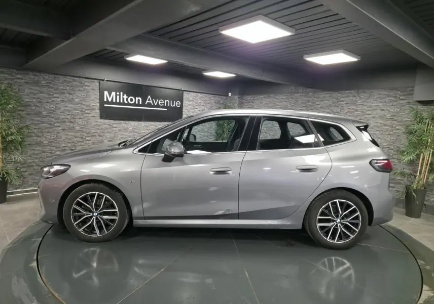 BMW Série 2 Active Tourer gris métallisé vue de profil côté gauche avec jantes alliage et poignées affleurantes.