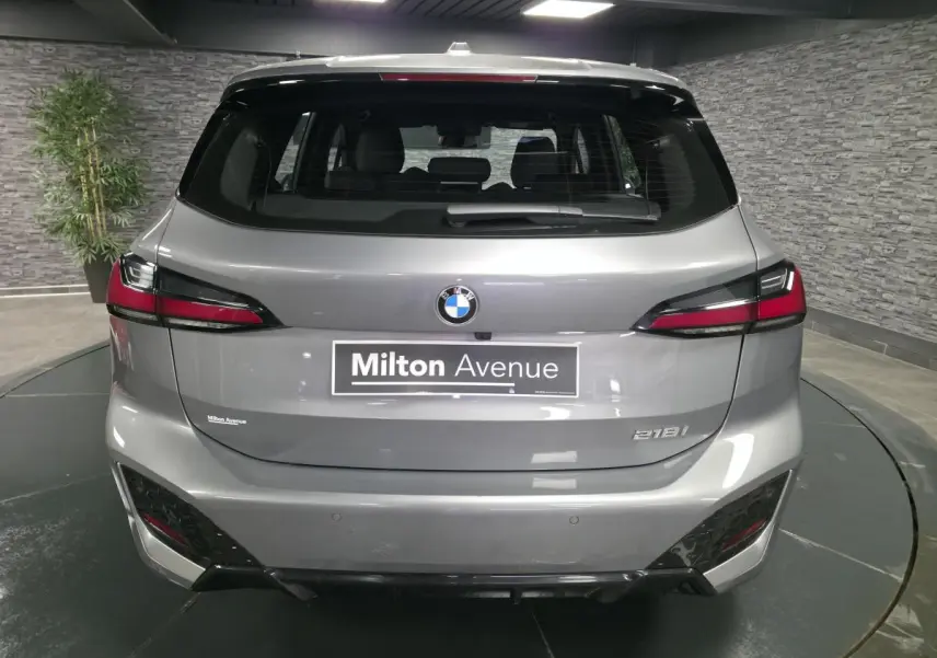 Vue arrière d'une BMW Série 2 218i Active Tourer grise avec feux arrière LED et logo BMW visible.