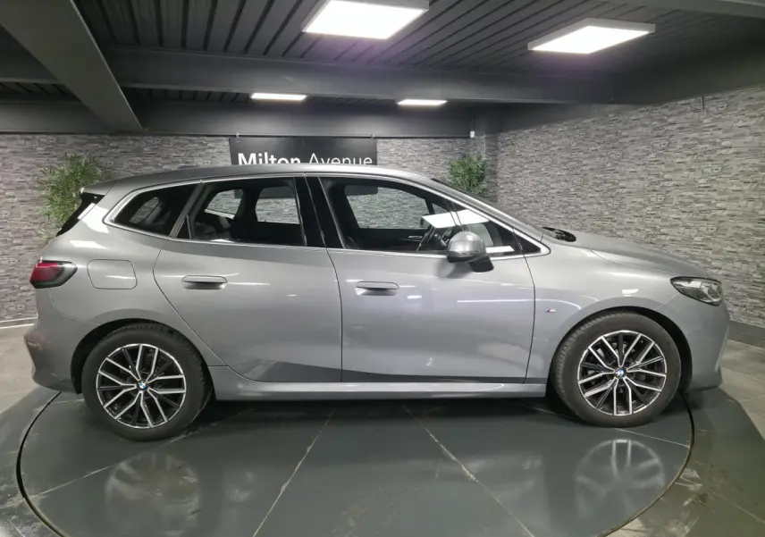 BMW Série 2 Active Tourer gris métallisé vue de profil côté gauche avec jantes alliage 18 pouces et badge M Sport.