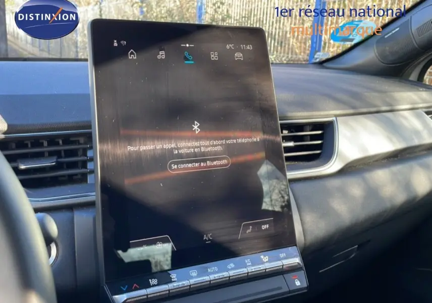 Vue intérieure centrée sur l'écran tactile du tableau de bord du Renault Captur gris Rafale métal avec toit noir.