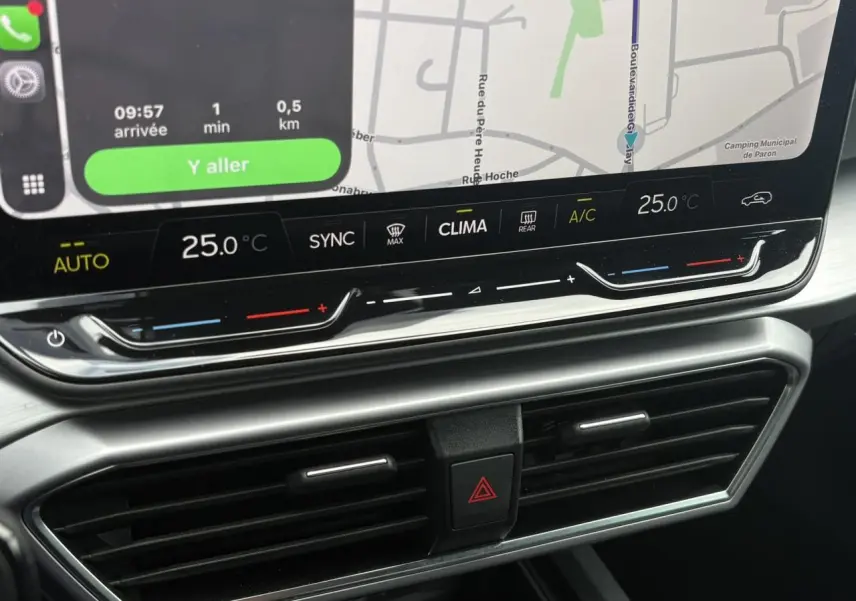 Gros plan sur la console centrale du SEAT LEON 2025, affichage tactile avec commandes climatisation et ventilation.