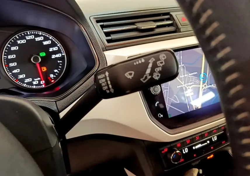 Vue rapprochée de l’intérieur du SEAT Arona gris clair 2019, montrant le volant, tableau de bord et écran tactile de navigation.