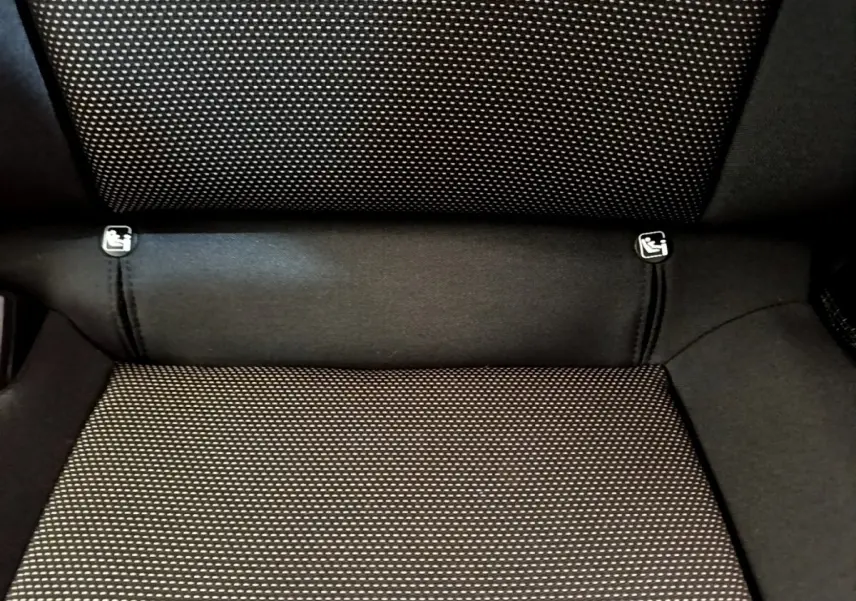 Gros plan sur la banquette arrière noire à motifs blancs du SEAT Arona, montrant les fixations Isofix.